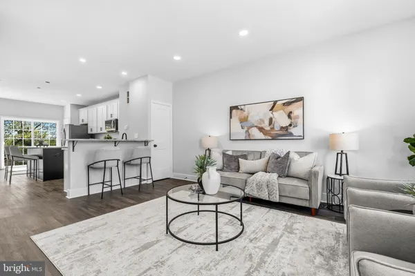a living room with furniture a refrigerator and kitchen view