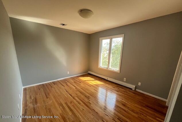 21 Alverson Loop Staten Island, NY 10309 - Photo 15 of 22 an empty room with wooden floor and windows