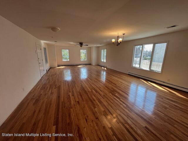21 Alverson Loop Staten Island, NY 10309 - Photo 2 of 22 wooden floor in an empty room with a window