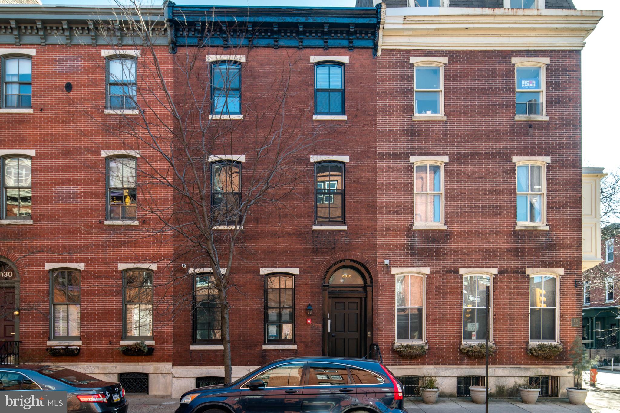 a front view of building with cars parked