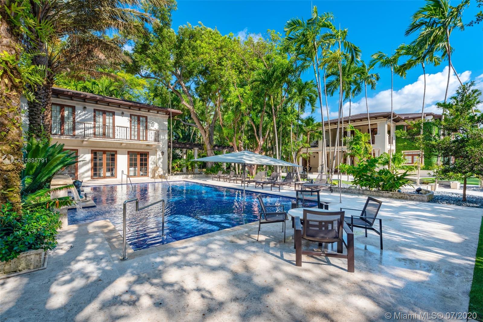 4800 Pine Drive Miami, FL 33143 - Photo 17 of 58 a view of a patio with a table and chairs under an umbrella