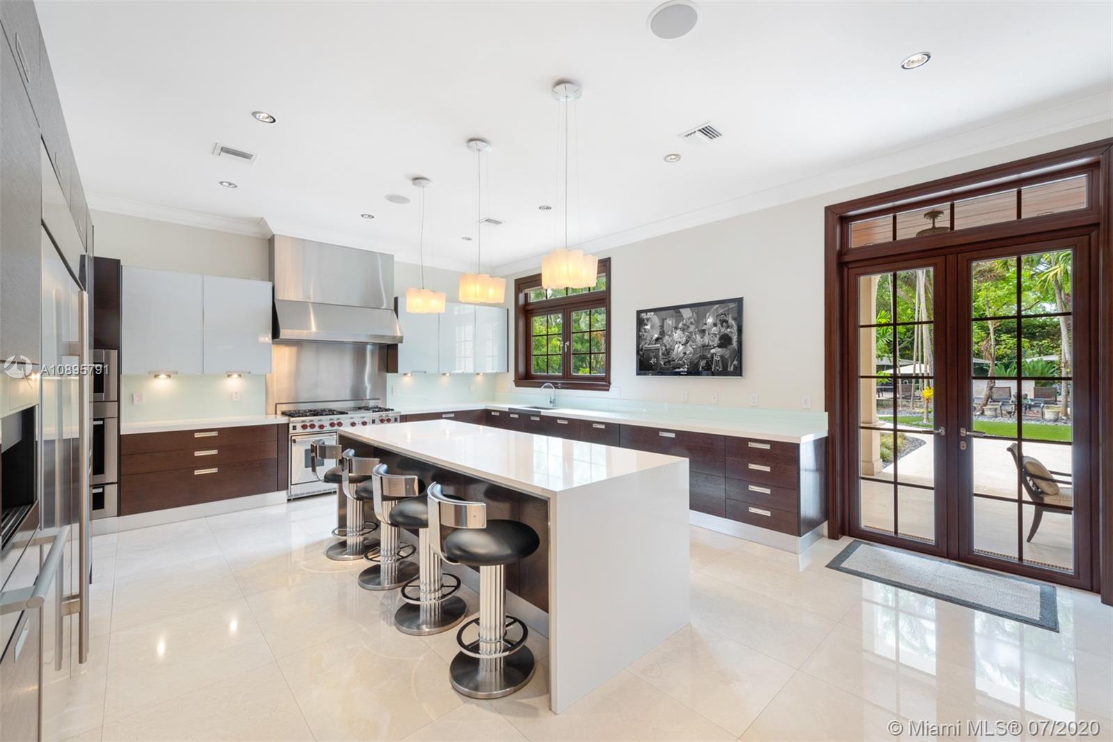 4800 Pine Drive Miami, FL 33143 - Photo 18 of 58 a large kitchen with kitchen island a large window a sink and a counter space