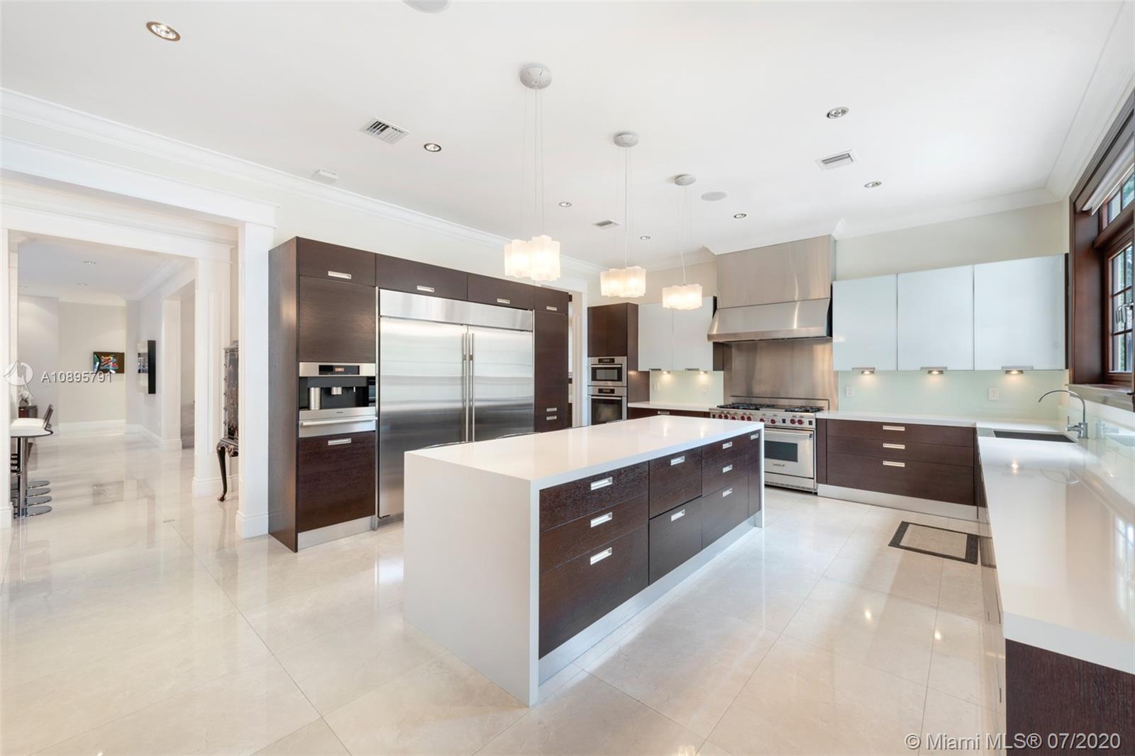 4800 Pine Drive Miami, FL 33143 - Photo 19 of 58 a large kitchen with kitchen island a sink a counter top stainless steel appliances and cabinets