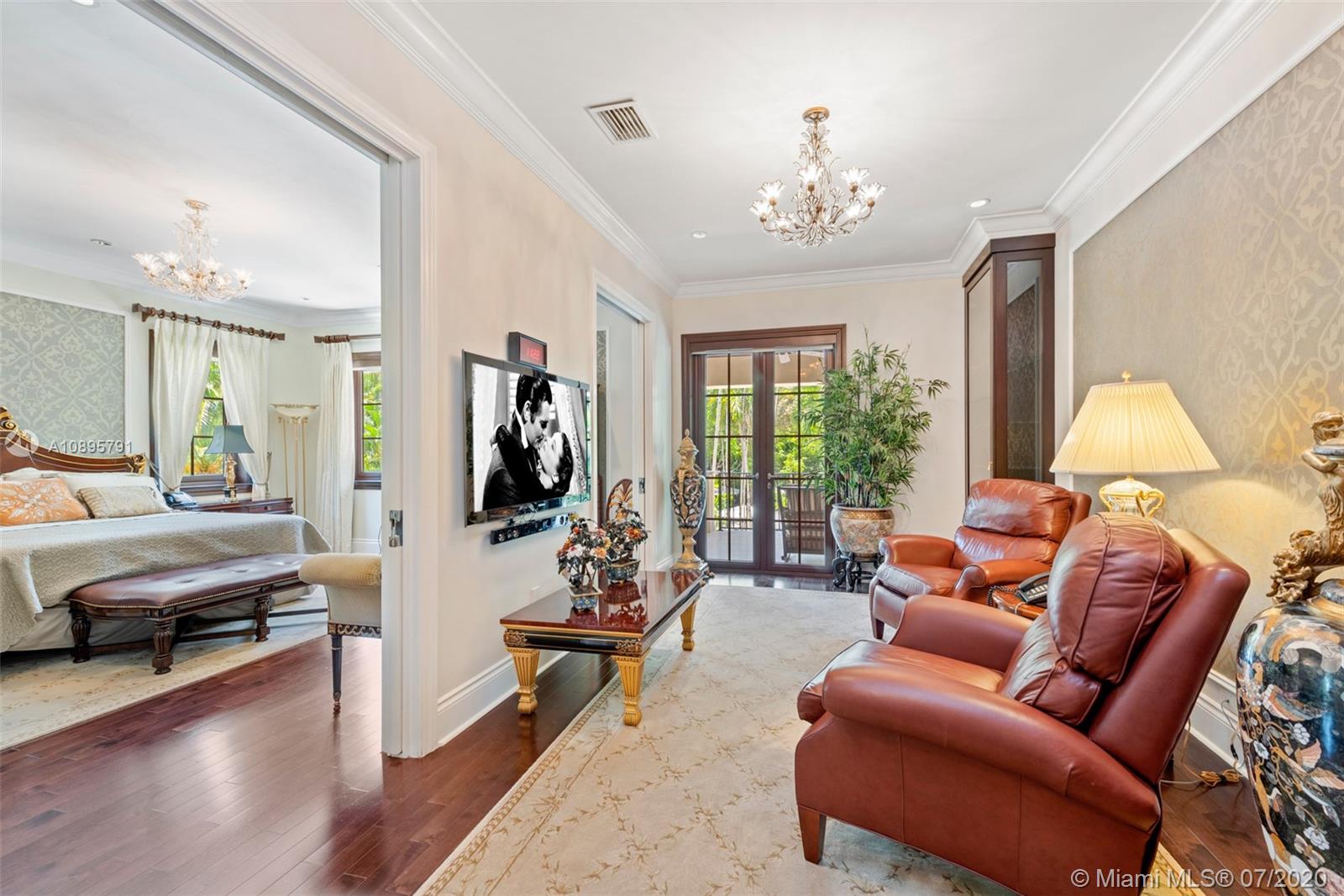 4800 Pine Drive Miami, FL 33143 - Photo 27 of 58 a living room with furniture a chandelier and a large mirror