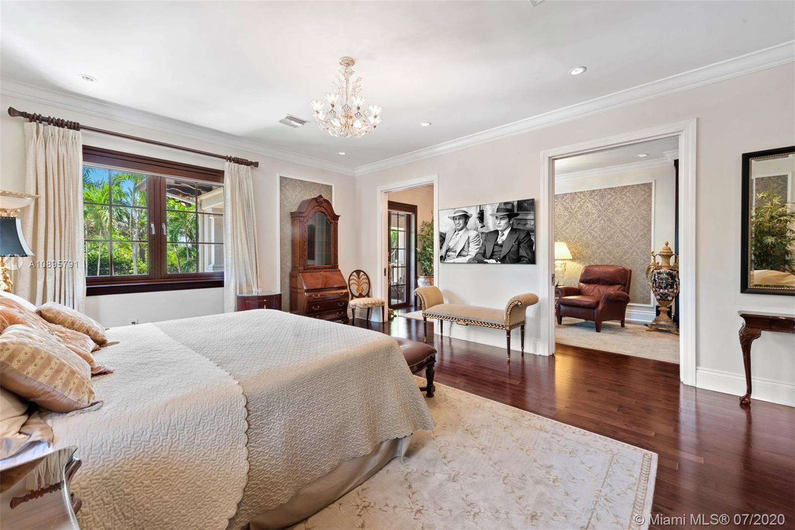 4800 Pine Drive Miami, FL 33143 - Photo 29 of 58 a spacious bedroom with a balcony a bed and wooden floor