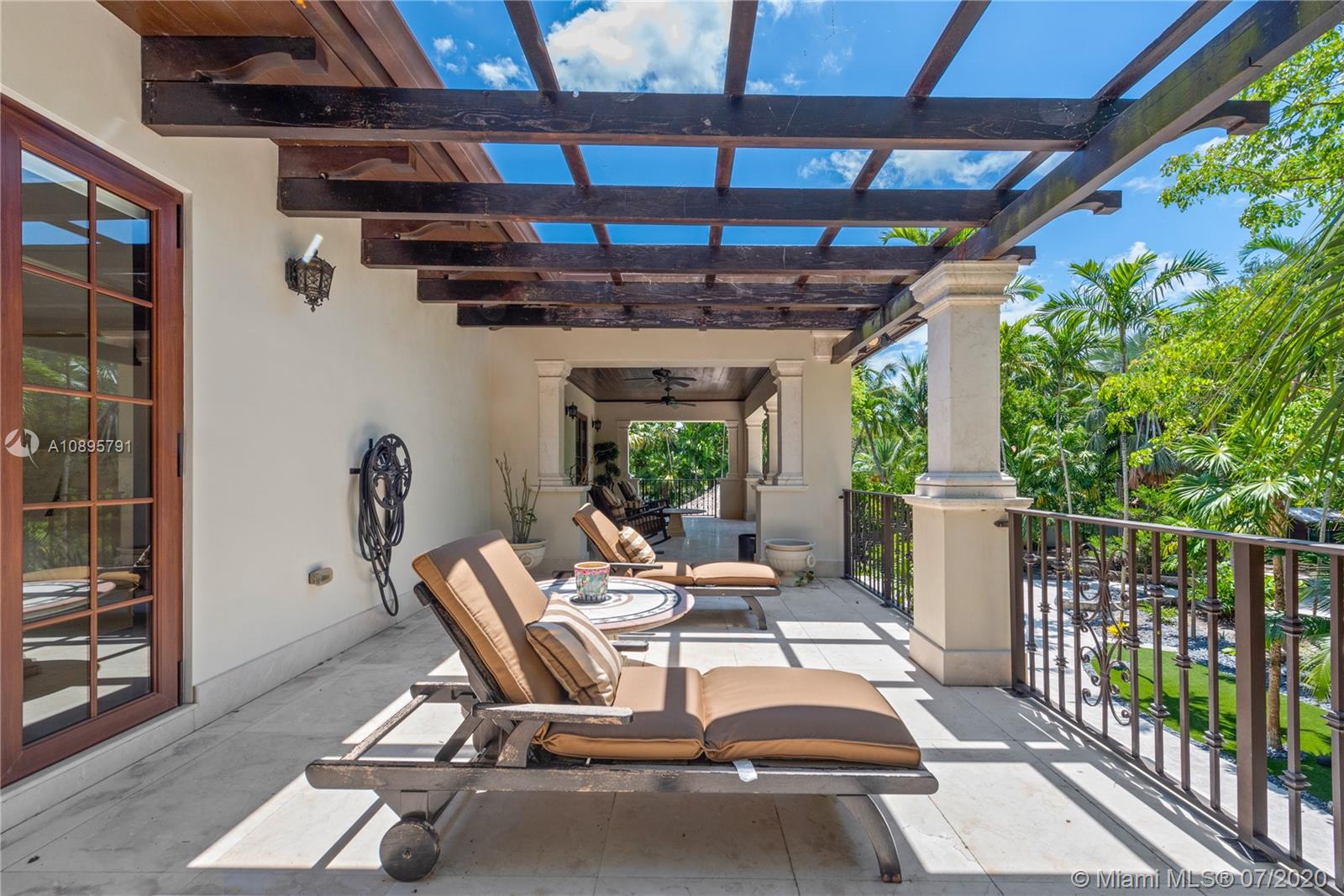 4800 Pine Drive Miami, FL 33143 - Photo 32 of 58 a view of a patio with table and chairs potted plants with wooden floor