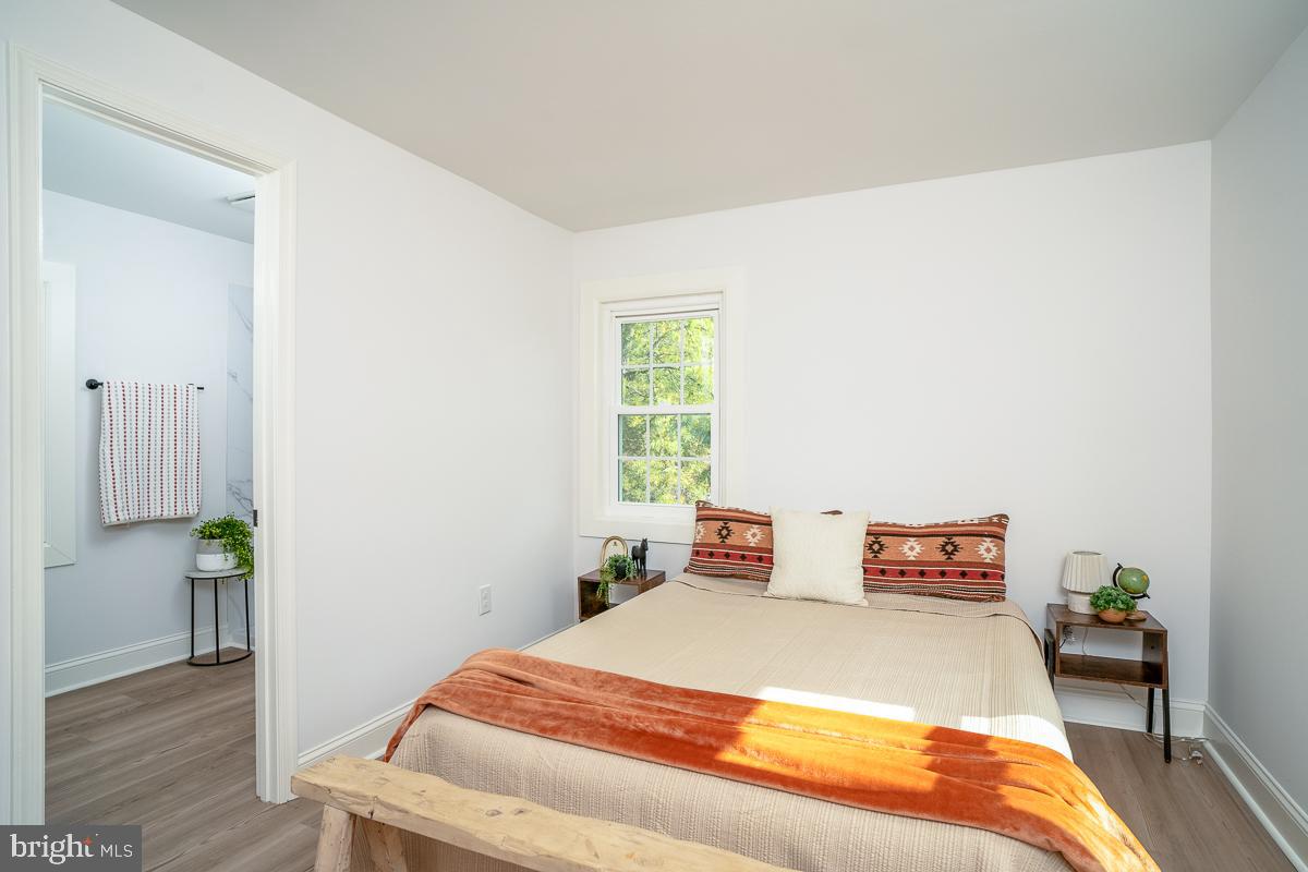 4771 Mill Creek Road Mount Jackson, VA 22842 - Photo 11 of 29 a bed sitting in a bedroom next to a window with wooden floor