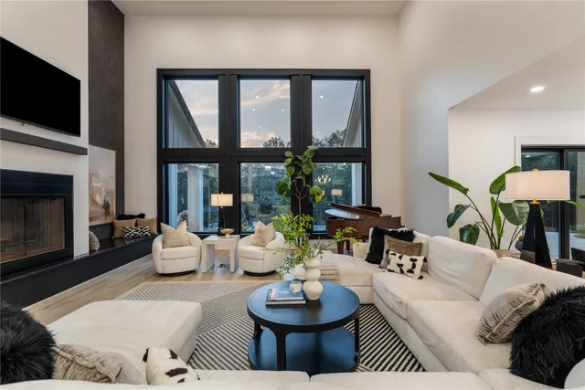 a living room with fireplace furniture and a large window