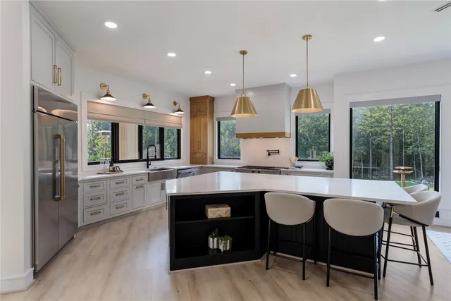 a kitchen with stainless steel appliances granite countertop a sink a stove and a wooden floors