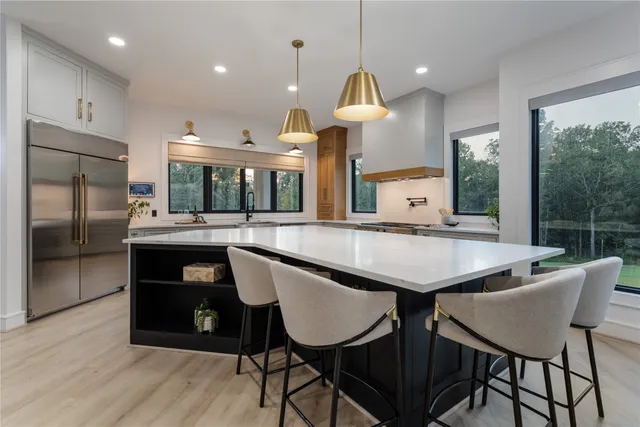 a kitchen with stainless steel appliances granite countertop a kitchen island a table and chairs in it