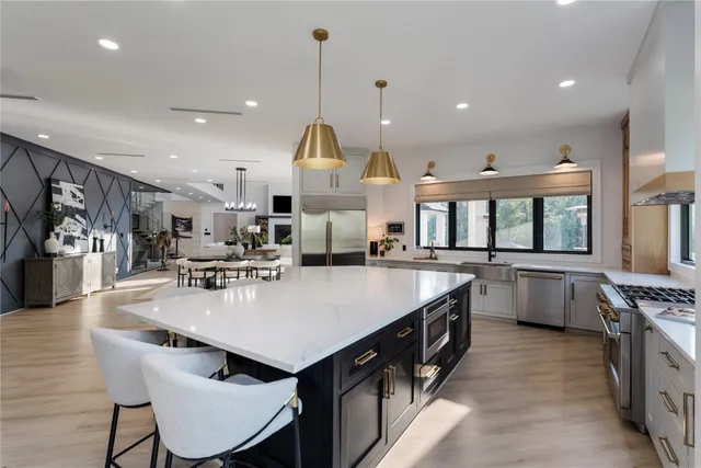 a large kitchen with stainless steel appliances kitchen island granite countertop a large center island and a stove