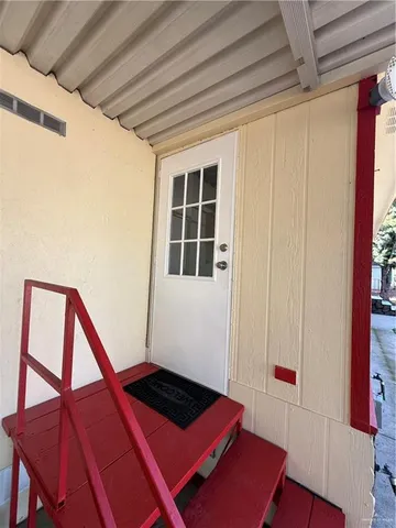 a view of an empty room with wooden floor and walls