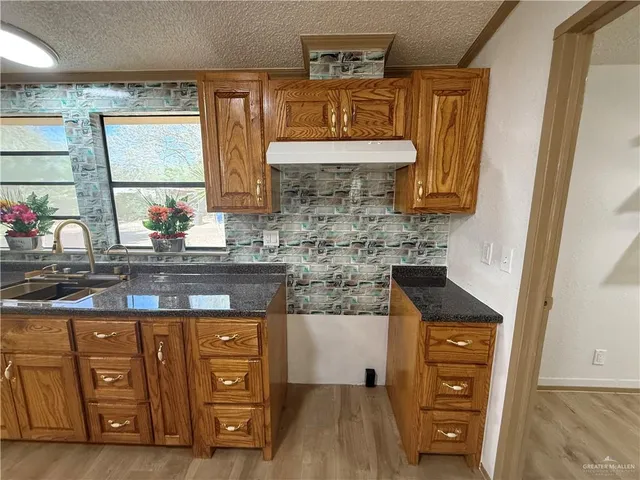 a kitchen with stainless steel appliances granite countertop a sink stove and cabinets