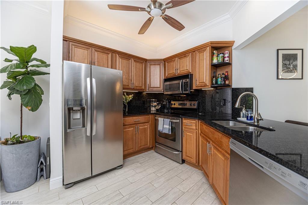 3735 Fieldstone Boulevard, Unit 9 Naples, FL 34109 - Photo 4 of 14 a kitchen with stainless steel appliances granite countertop a refrigerator a sink a stove a washer dryer and a refrigerator