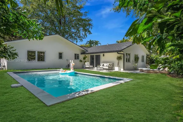 a view of a house with a yard patio and swimming pool
