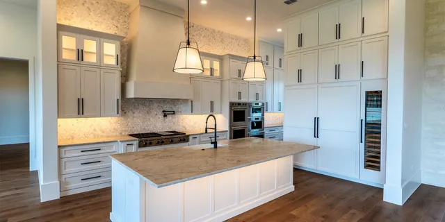 a kitchen with stainless steel appliances granite countertop a sink a stove and a refrigerator
