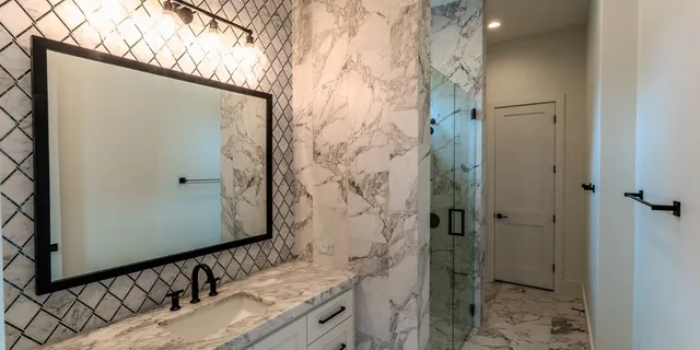 a bathroom with a granite countertop shower and a sink