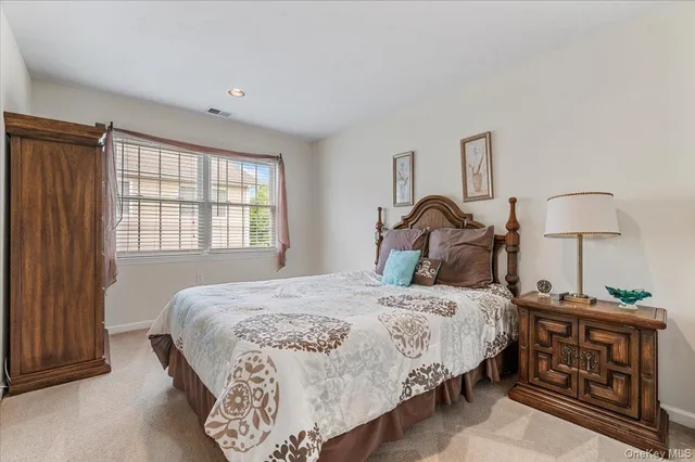 a bedroom with a bed a mirror and a window