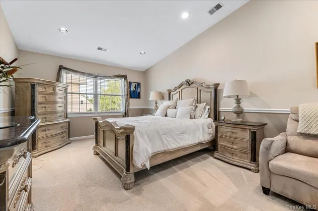 a spacious bedroom with a bed couch and a large window