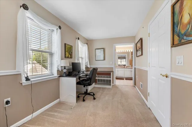 a view of a livingroom with workspace and a window