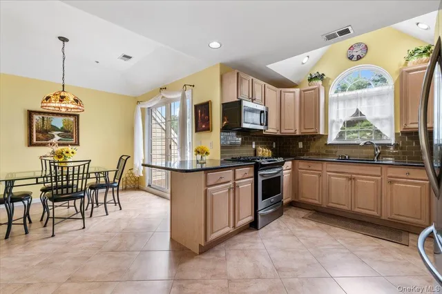 a kitchen with stainless steel appliances granite countertop a stove top oven a sink a counter top space and cabinets