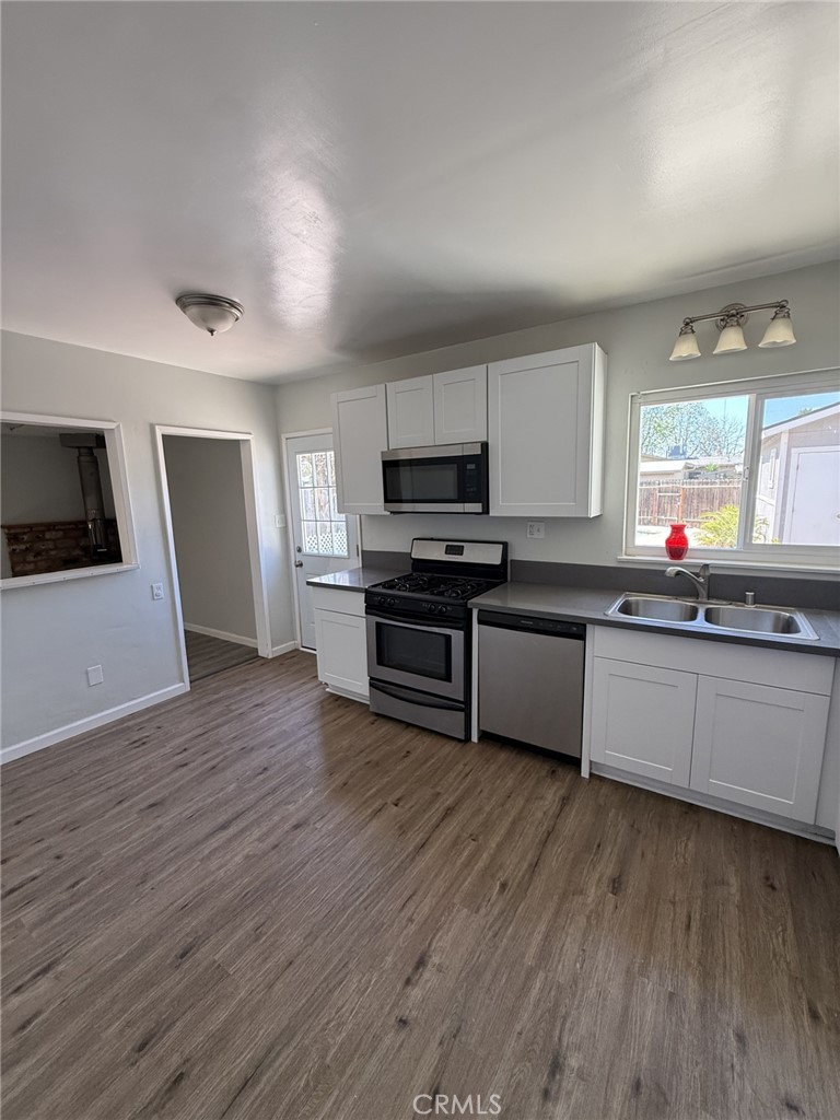 319 Elm Street Shafter, CA 93263 - Photo 7 of 14 a kitchen with wooden floors and appliances