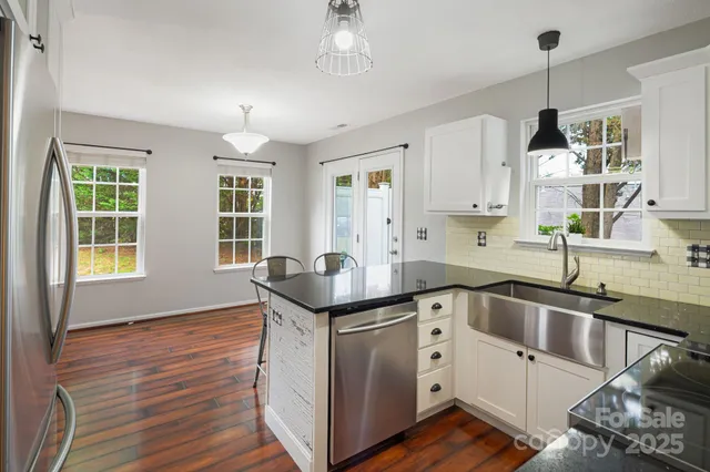 a kitchen with granite countertop a sink and cabinets
