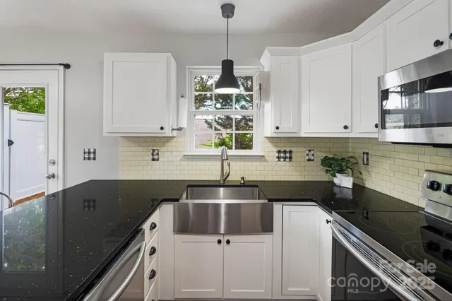 a kitchen that has a sink and a stove in it