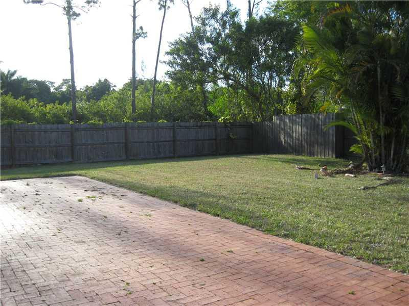 11197 Model Circle West Boca Raton, FL 33428 - Photo 20 of 23 a view of a backyard with large trees and wooden fence