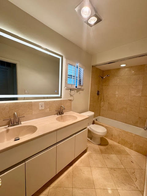 5520 North Ocean Boulevard, Unit 201 Ocean Ridge, FL 33435 - Photo 14 of 17 a bathroom with a double vanity sink toilet mirror and bathtub