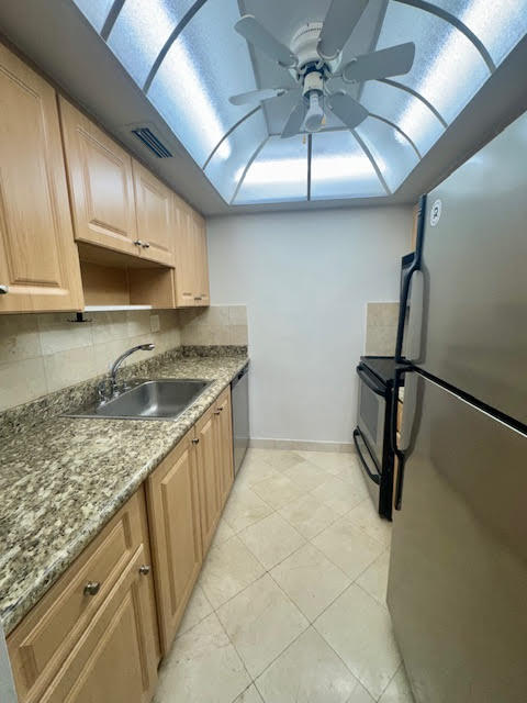 5520 North Ocean Boulevard, Unit 201 Ocean Ridge, FL 33435 - Photo 7 of 17 a kitchen with granite countertop a sink a stove and cabinets