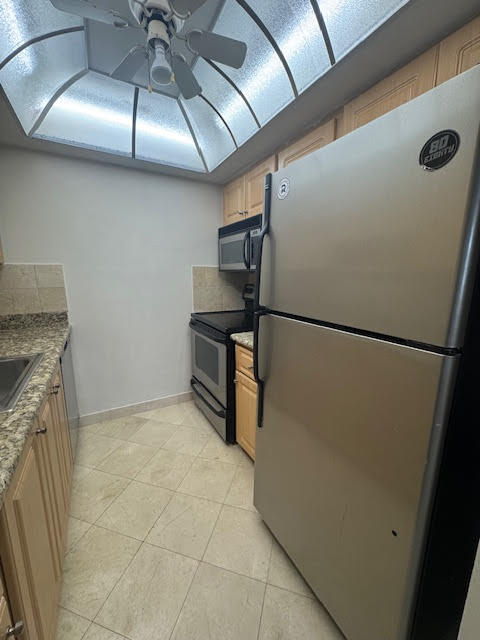 5520 North Ocean Boulevard, Unit 201 Ocean Ridge, FL 33435 - Photo 8 of 17 a kitchen with stainless steel appliances a refrigerator and a counter