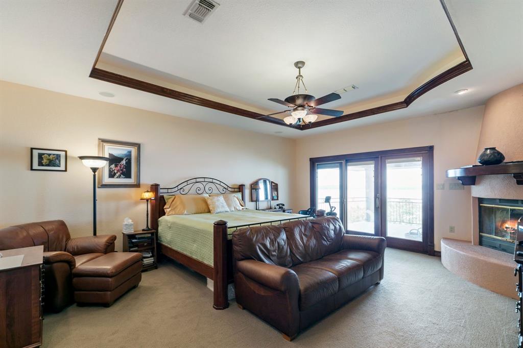 9957 Boat Club Road Fort Worth, TX 76179 - Photo 26 of 38 a spacious bedroom with a bed furniture and a fireplace