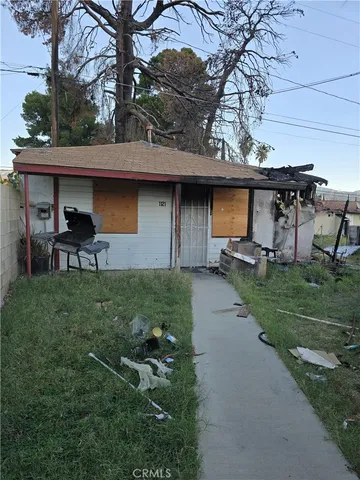 a view of a chair and table in backyard of the house