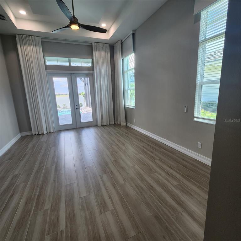 512 Blue Shell Loop Sarasota, FL 34240 - Photo 17 of 44 an empty room with wooden floor and windows