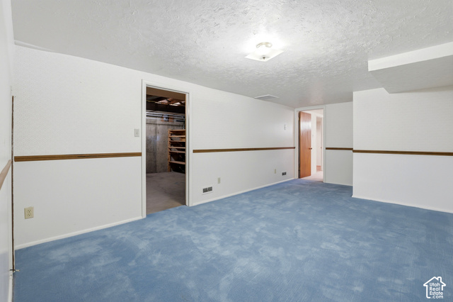 380 North 300 East Mapleton, UT 84664 - Photo 18 of 35 Spacious room with blue carpeting, white walls, wood trim accent, and a flush mount ceiling light