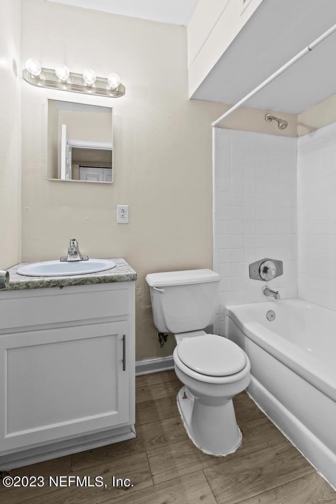 7256 Merrill Road Jacksonville, FL 32277 - Photo 23 of 36 a bathroom with a granite countertop toilet a sink and a bathtub