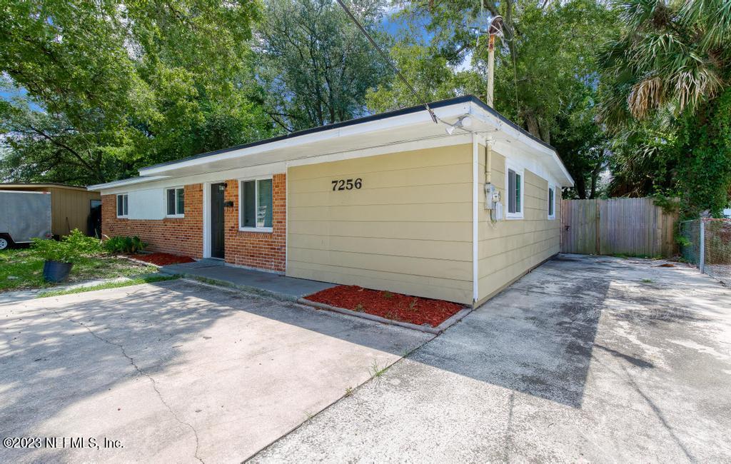 7256 Merrill Road Jacksonville, FL 32277 - Photo 6 of 36 a side view of a house with a yard