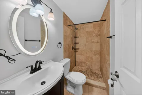 a bathroom with a sink mirror toilet and shower
