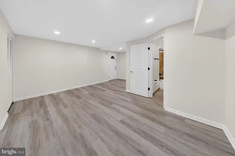 a view of a room with wooden floors and white walls