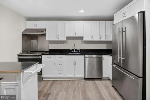 a kitchen with a refrigerator sink and cabinets