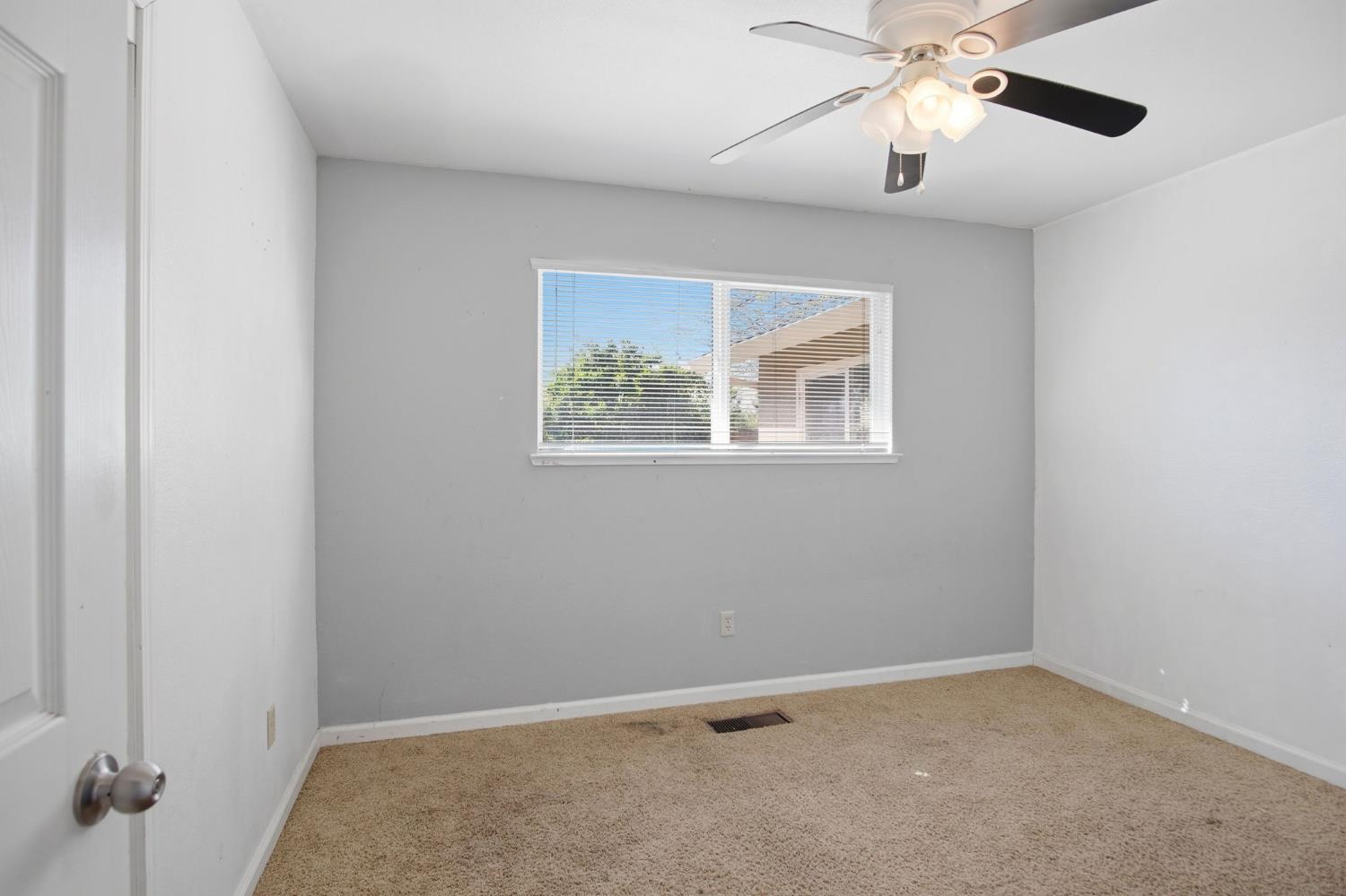 1409 Stonum Road Modesto, CA 95351 - Photo 15 of 40 an empty room with a window and a fan