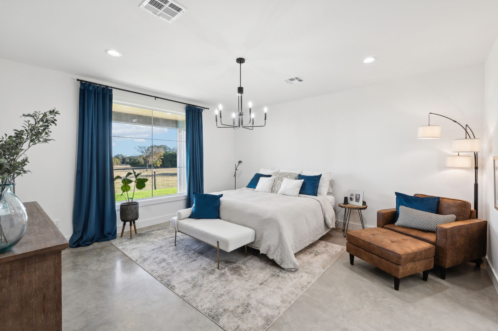 10433 County Road 162 Somerville, TX 77879 - Photo 20 of 40 a spacious bedroom with two beds and a chandelier