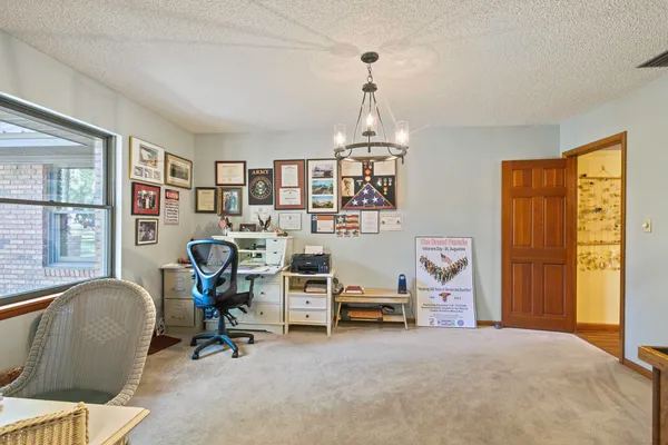 a view of a workspace with furniture and a window