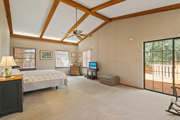 a spacious bedroom with furniture and a large window