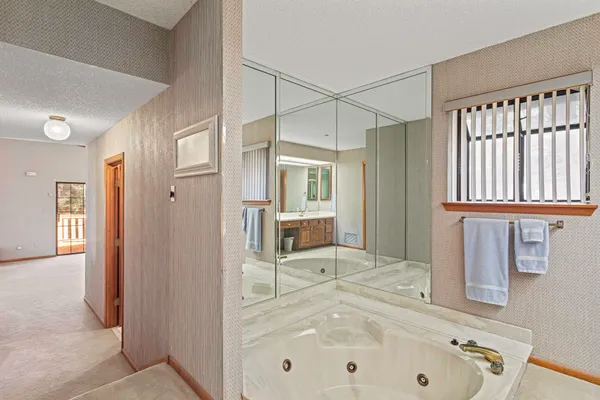 a bathroom with a tub sink and mirror