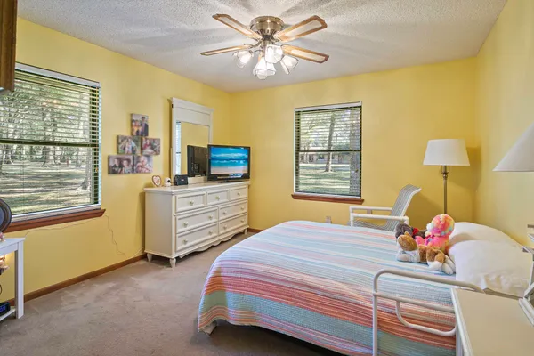 a bedroom with a bed dresser and a window