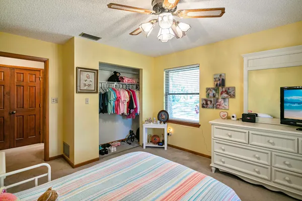 a bed room with a bed and a mirror on a dresser