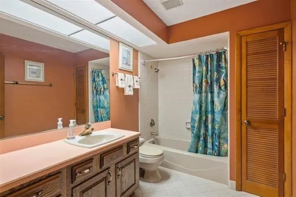 a bathroom with a granite countertop sink toilet and shower