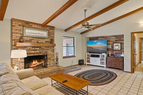a living room with furniture a flat screen tv and a fireplace